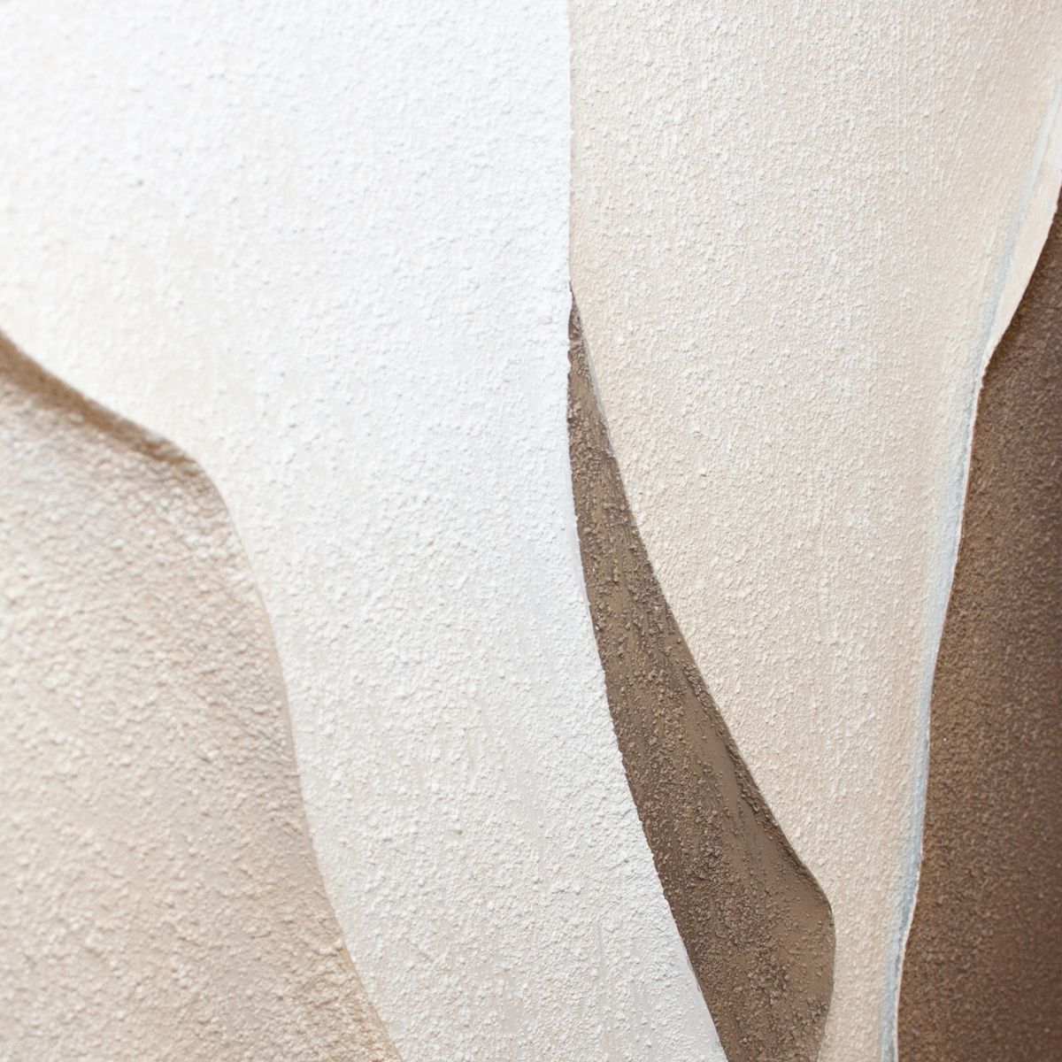 Detalle en relieve de cuadro abstracto texturizado con formas curvas en tonos neutros