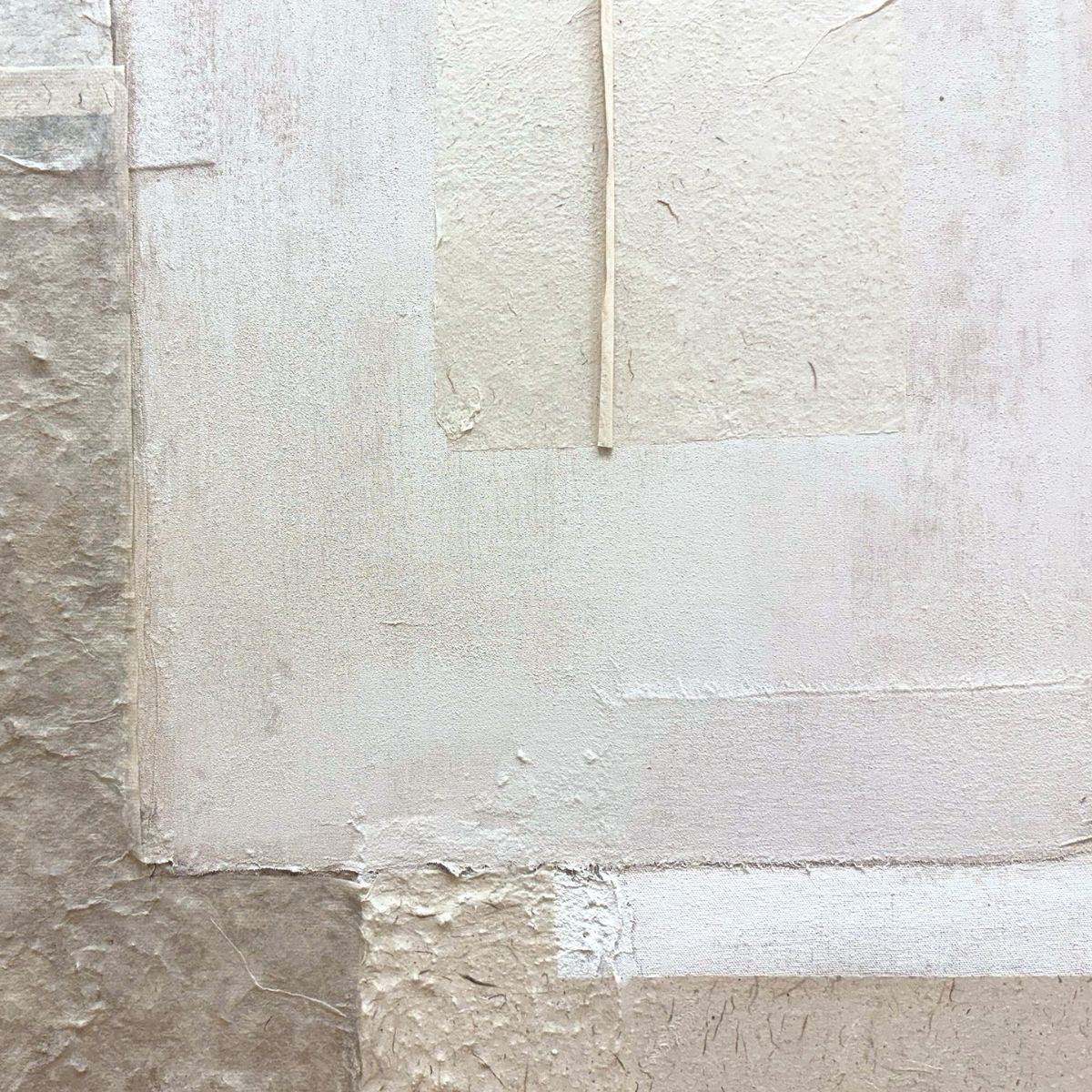 Detalle de cuadro abstracto con superposición de texturas en tonos beige y gris