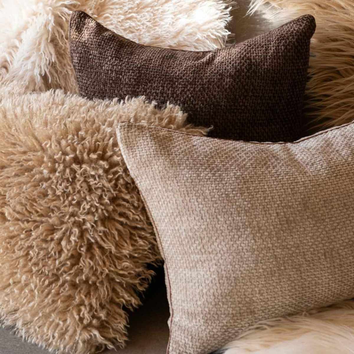 Tres cojines suaves en tonos marrones y beige