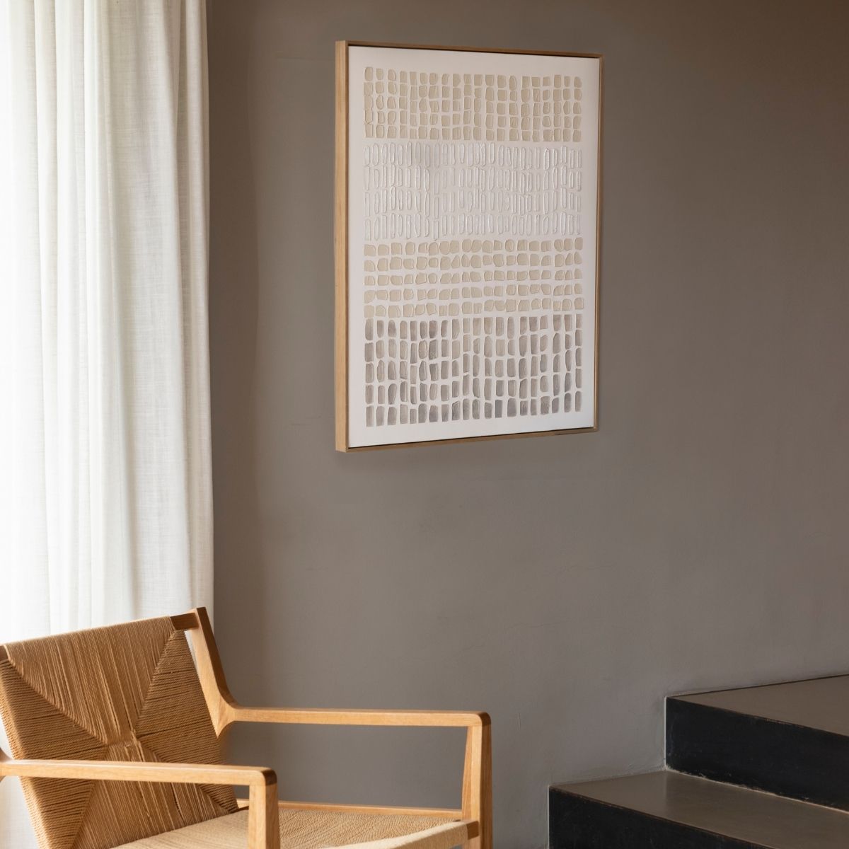 Cuadro abstracto en tonos beige con marco de madera en pared de salón