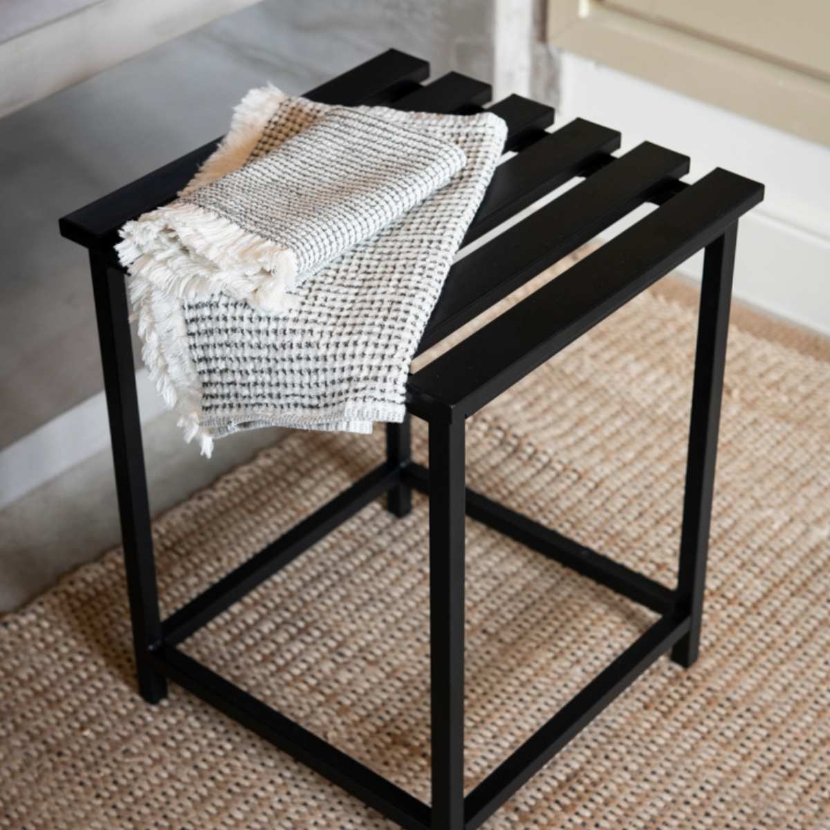 Taburete de baño negro con toalla