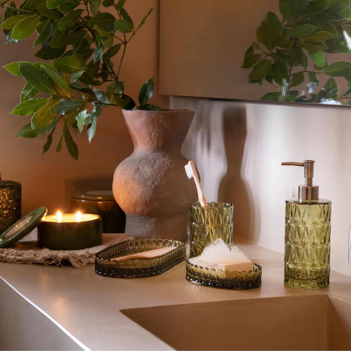 Jabonera de vidrio verde Pear en ambiente de baño con plantas, Andrea House