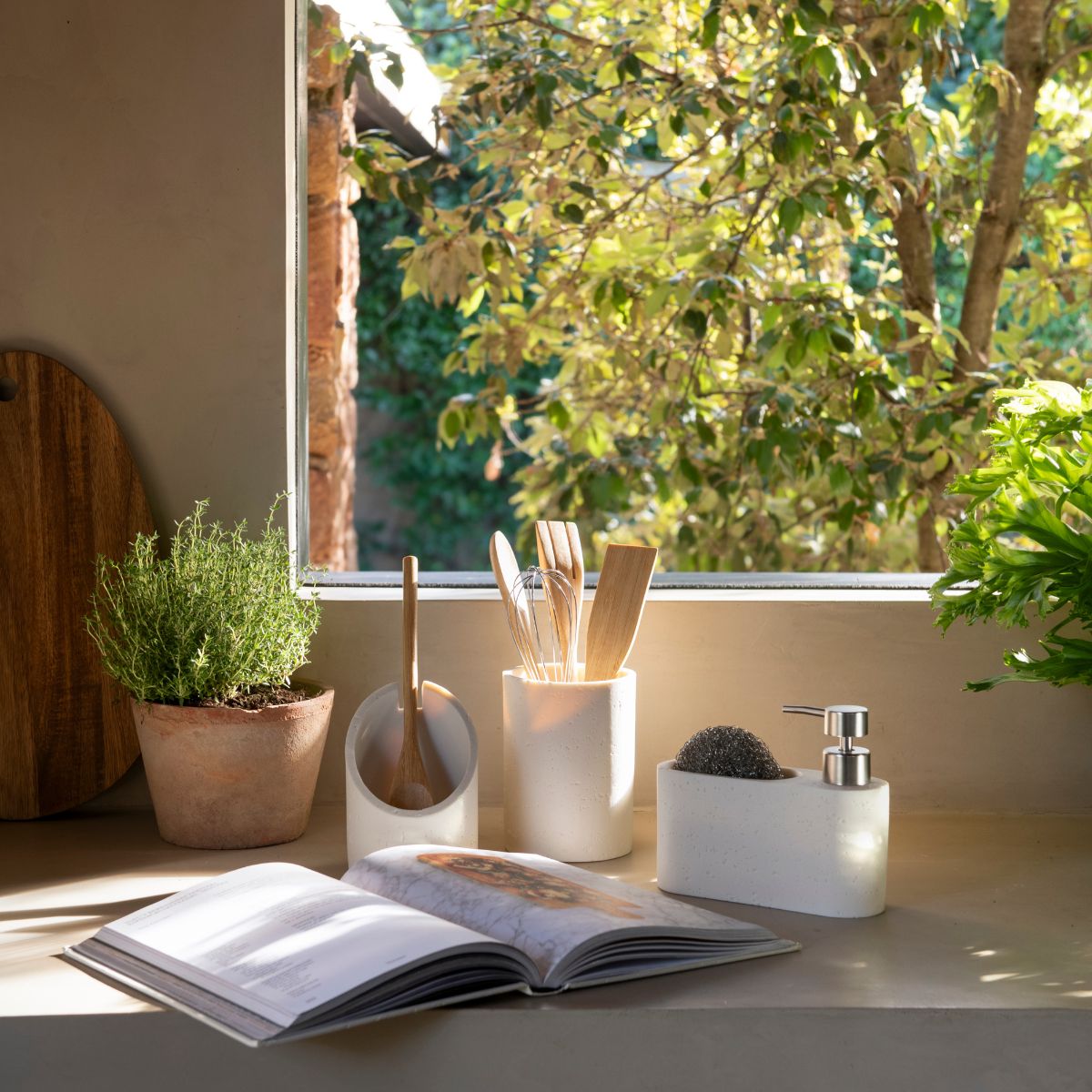 Dispensador efecto piedra crema junto al fregadero en cocina natural, Andrea House