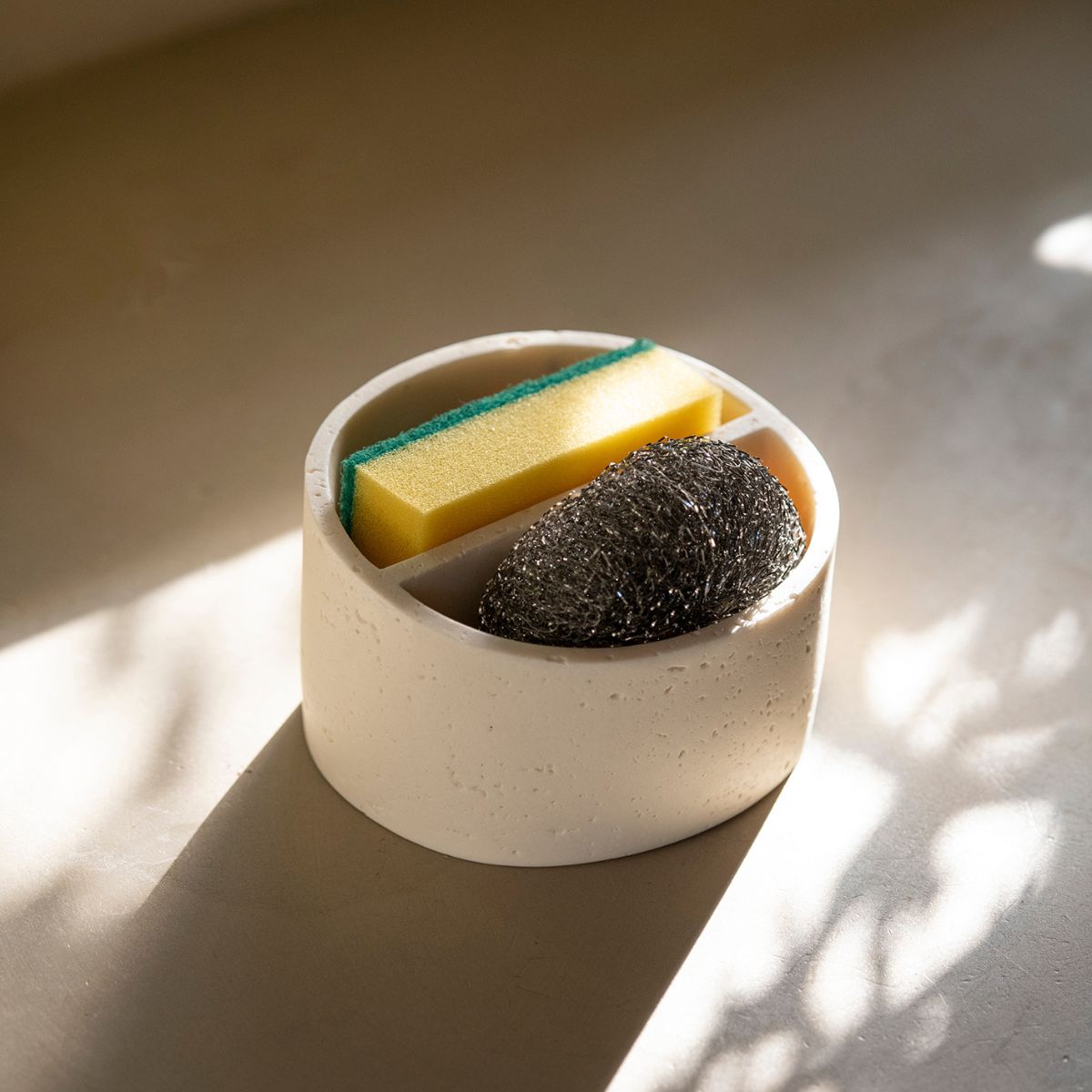 Soporte para estropajo efecto piedra crema junto al fregadero en cocina, Andrea House