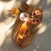Tabla de madera de acacia con pan y aperitivos para servir