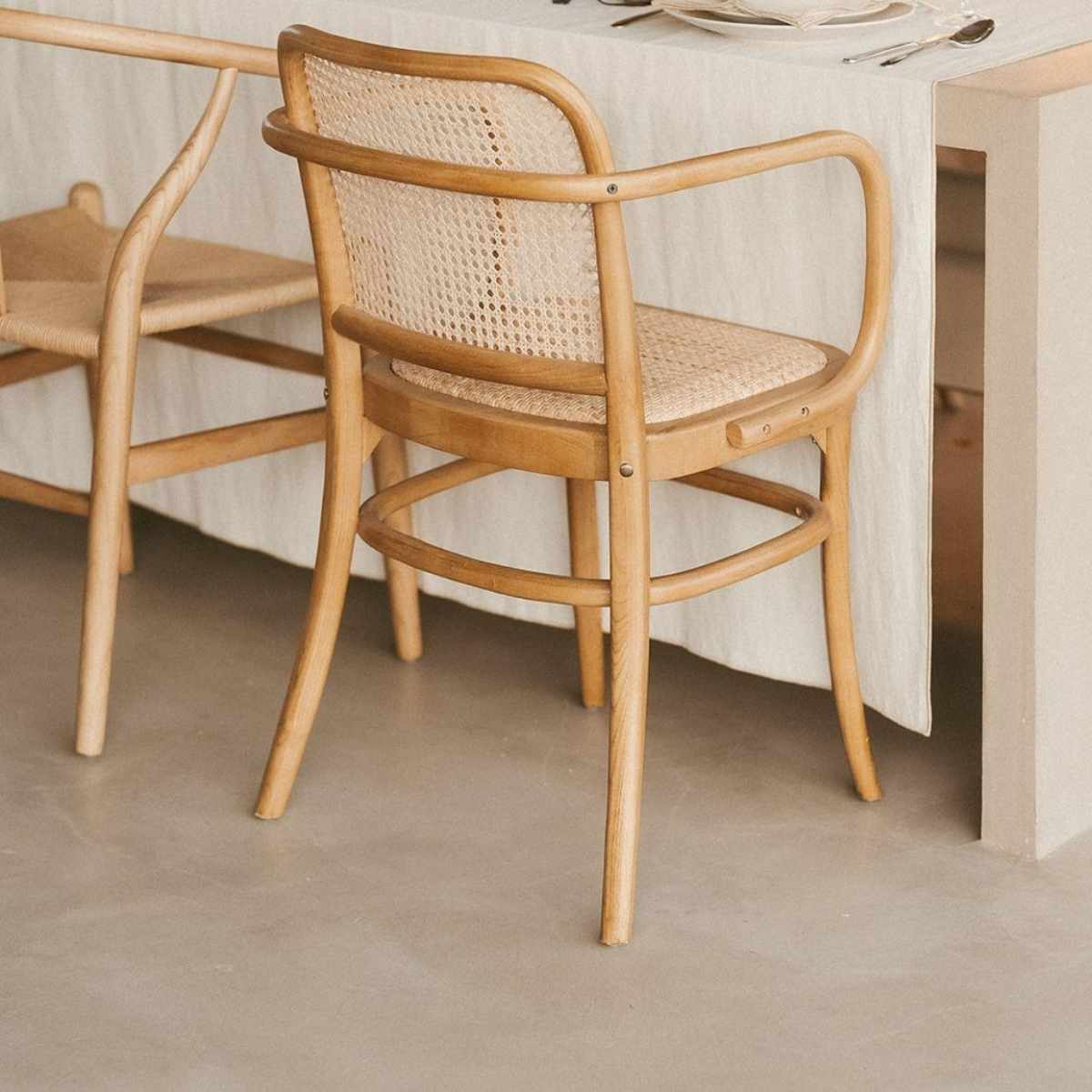 Silla de madera en mesa con mantel de lino beige