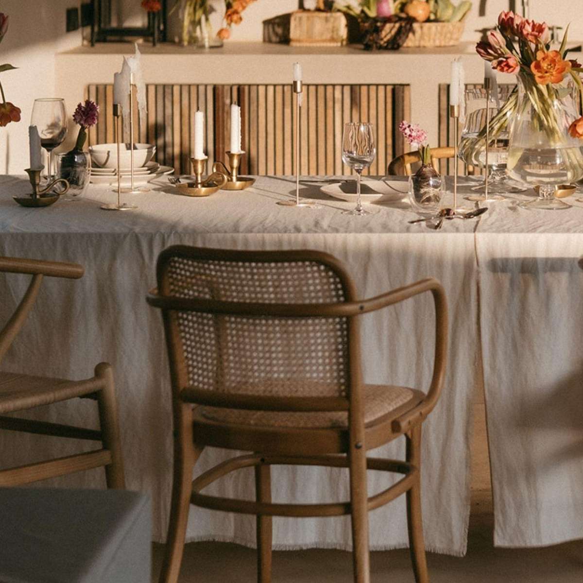 Mesa elegante con mantel de lino beige y silla de madera