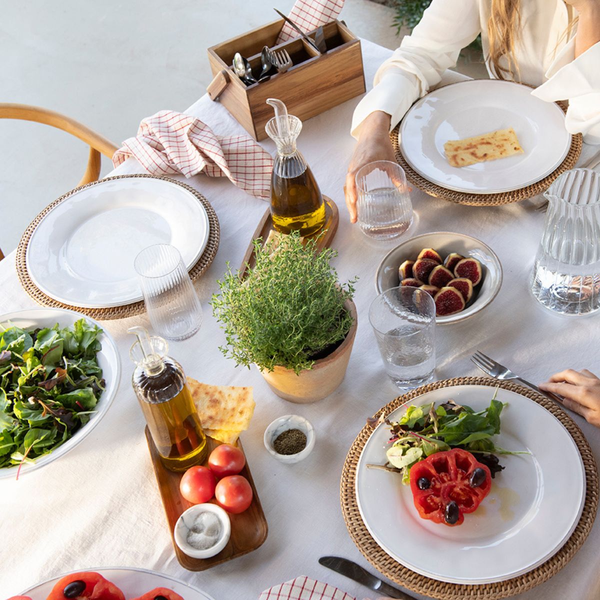 Set de dos cuencos de mármol para especias en mesa de verano con ensaladas aceiteras y bajoplatos