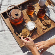 Bandeja de servir de acacia con desayuno y bebidas sobre mesa