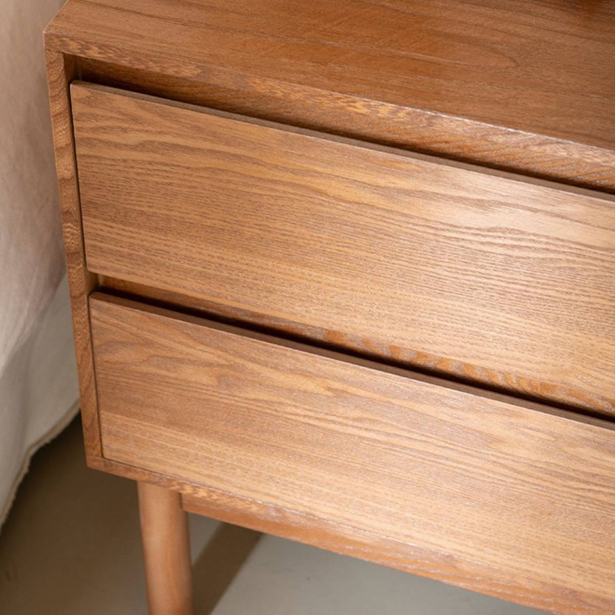 Detalle de mesita de noche de madera de fresno oscuro