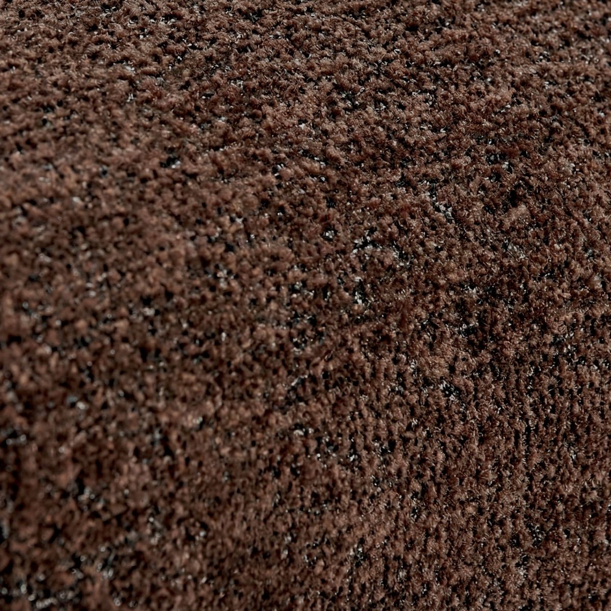 Detalle del tejido marrón de textura rizada de la butaca.
