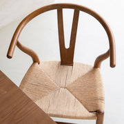 Vista superior de silla de comedor de madera con respaldo curvo y asiento de fibra trenzada