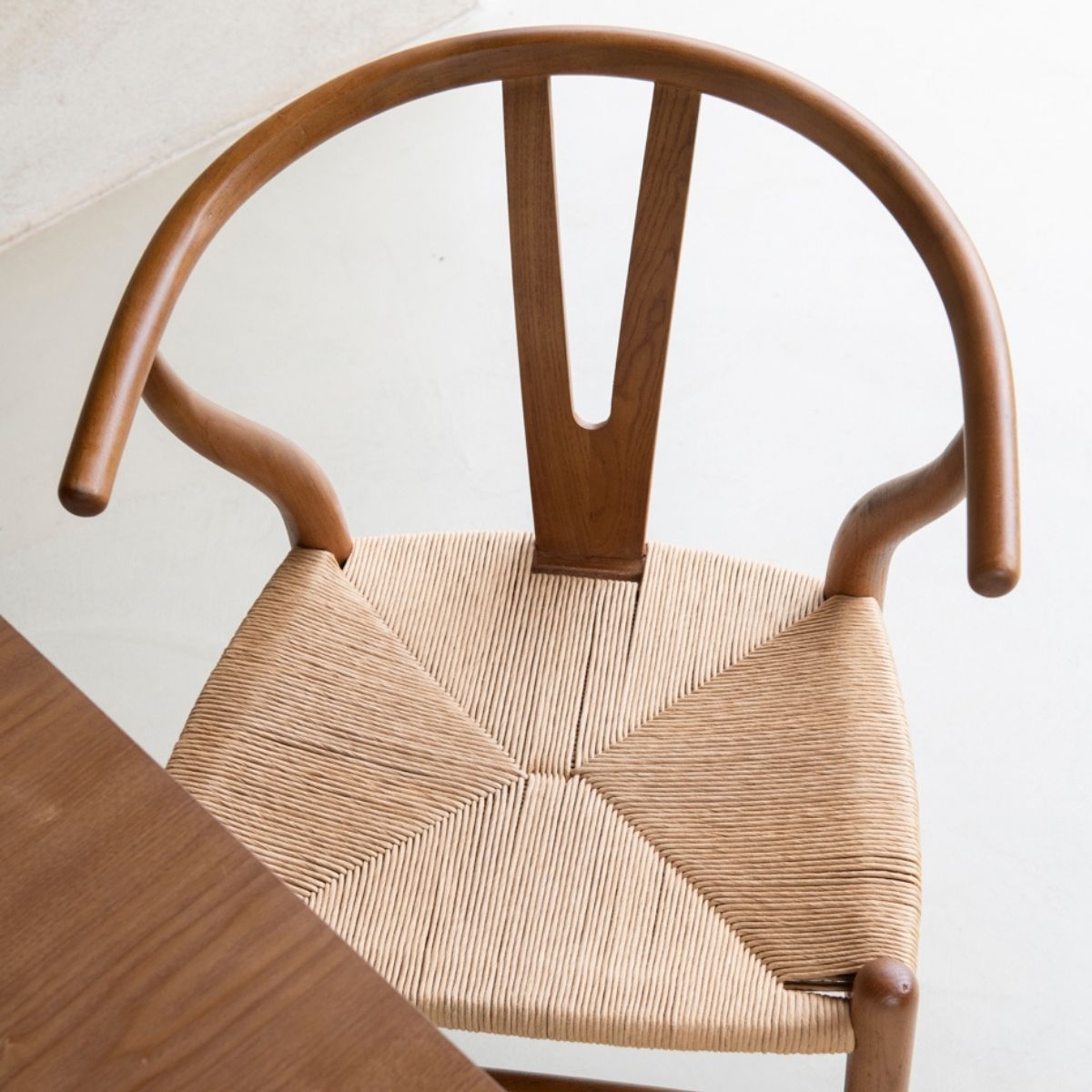 Vista superior de silla de comedor de madera con respaldo curvo y asiento de fibra trenzada